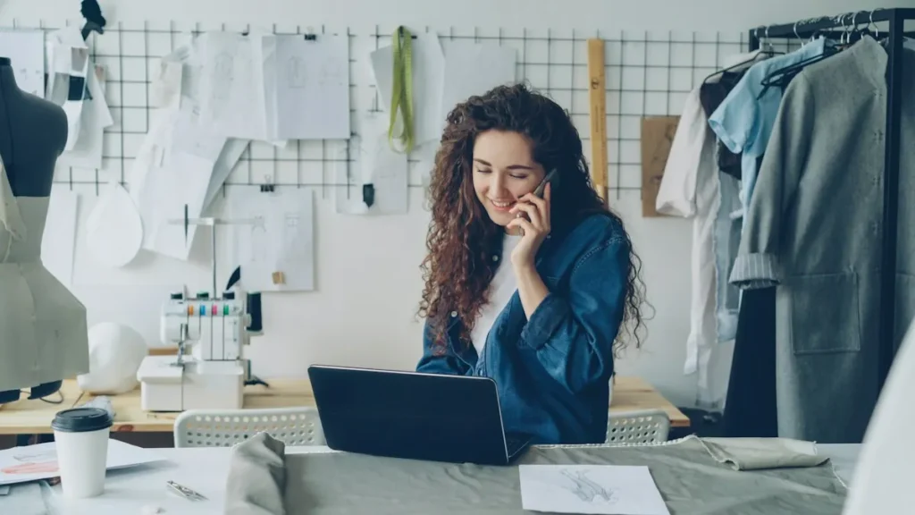 Emprendedora con el móvil y el portátil gestionando redes sociales para negocios